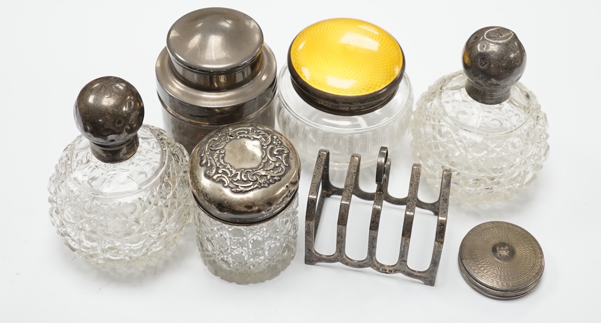 A George V silver tea? cannister, by Mappin & Webb, five silver mounted dressing accessories and a silver toast rack